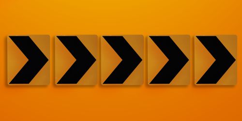 Orange direction signs on orange wall